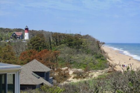a beach and a red and white light house